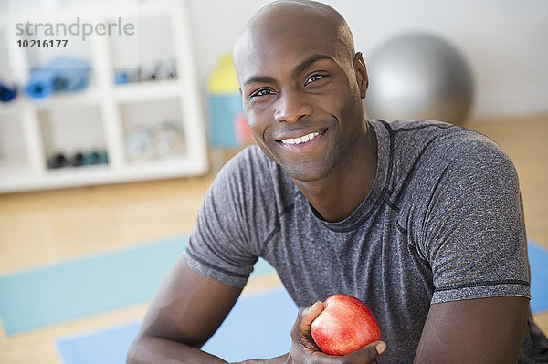 Fitness-Studio Mann schwarz Apfel essen essend isst