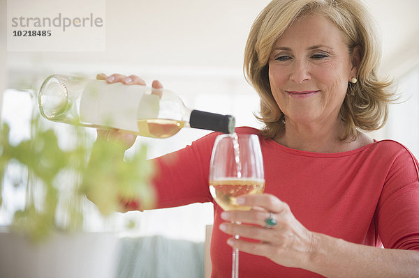 Europäer Frau Glas eingießen einschenken Weißwein