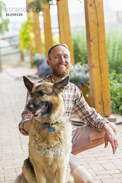 Europäer Mann Hund streicheln Veranda