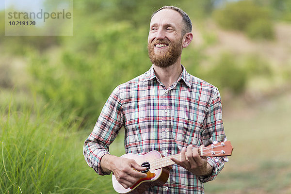 Außenaufnahme Europäer Mann Ukulele freie Natur spielen