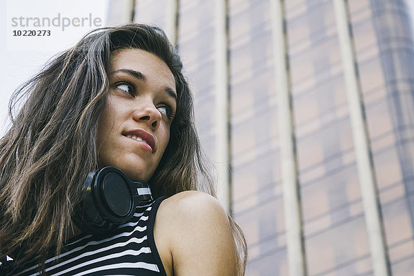 Porträt eines jungen Mädchens mit Kopfhörer vor dem Wolkenkratzer