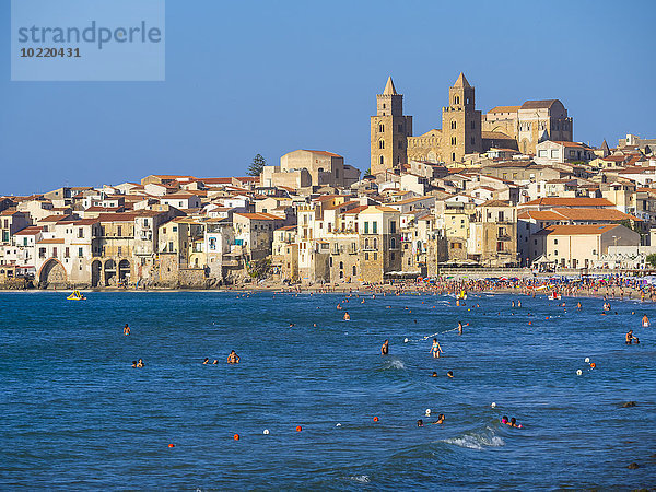 Italien  Sizilien  Cefalu  Ansicht von Cefalu mit Cefalu Kathedrale  Strand und Touristen im Wasser