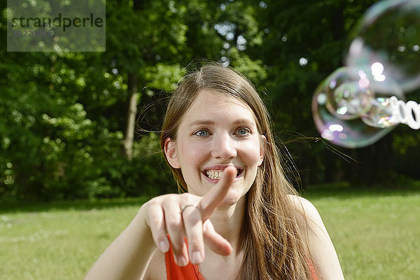 Junge Frau spielt mit Seifenblasen