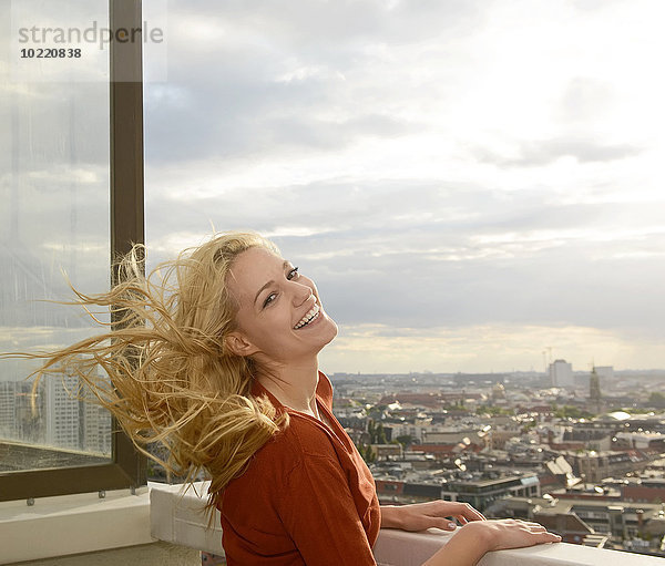 Deutschland  Berlin  Porträt einer glücklichen jungen Frau mit wehendem Haar