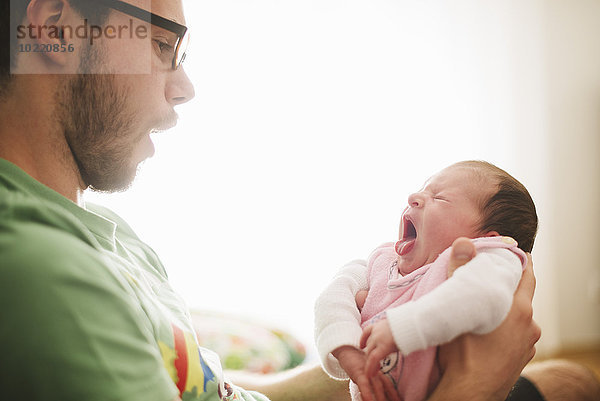 Junger Mann mit seiner neugeborenen Tochter