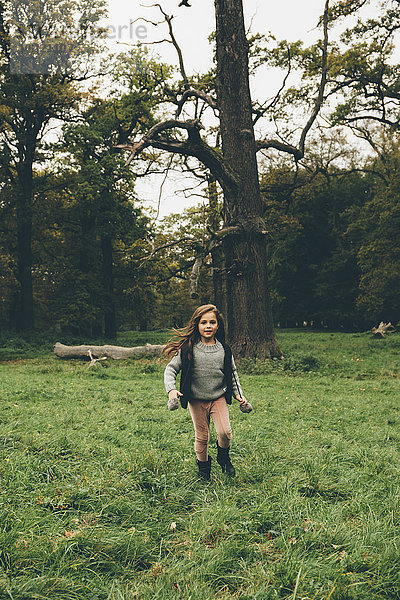 Kleines Mädchen rennt auf einer Wiese im Park