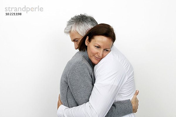 Paar umarmt sich vor weißem Hintergrund