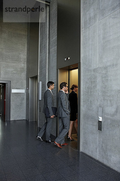 Gruppe von Geschäftsleuten  die den Aufzug im Büro betreten