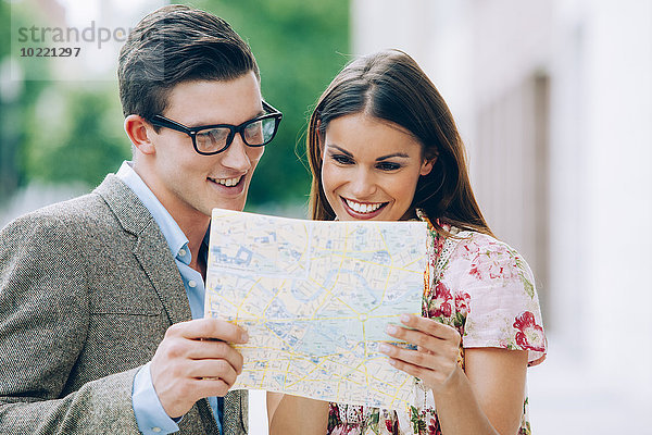 Lächelndes junges Paar beim Lesen der Karte
