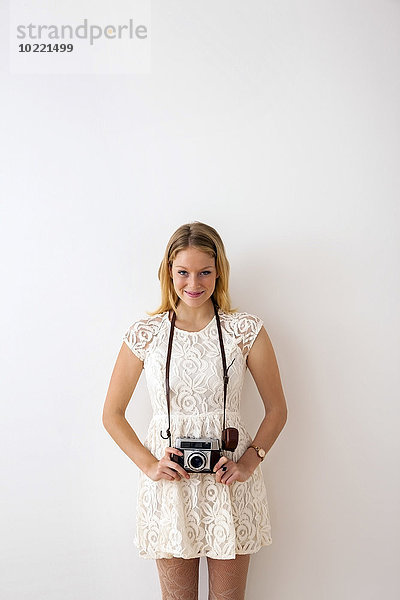 Lächelnde junge Frau mit alter Kamera