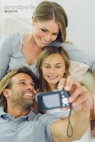 Glücklicher Vater  Mutter und Tochter  die einen Selfie auf der Couch haben.