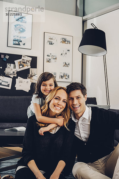 Glückliche Familie mit Tochter im Wohnzimmer