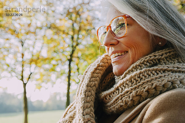 Porträt einer lächelnden Frau mit Schal und Brille