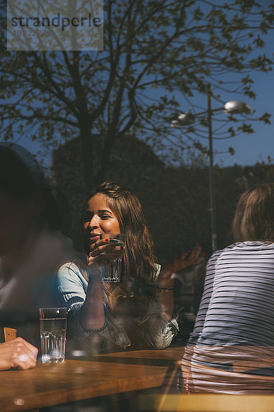 Junge Frau sitzt im Café und redet.