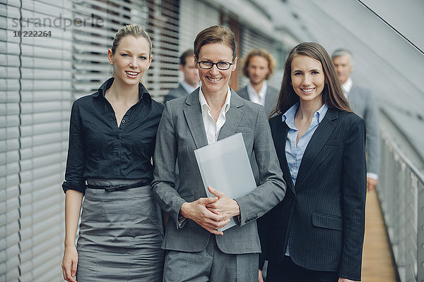 Reife Geschäftsfrau mit Kollegen im Hintergrund
