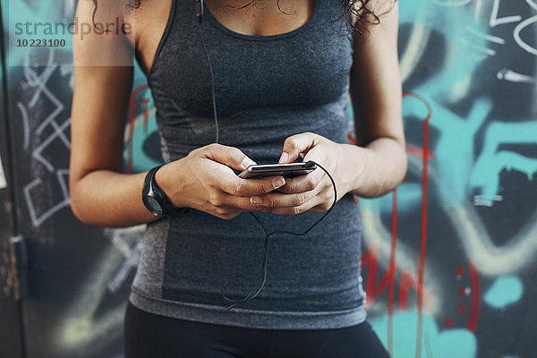 Junge Frau mit Smartphone  Musik hören mit Kopfhörer  Nahaufnahme