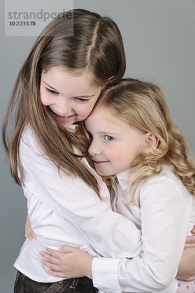 Zwei kleine Schwestern  die sich umarmen.