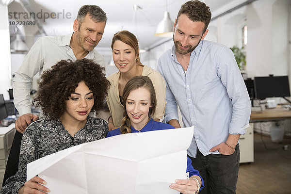 Kollegen im Büro beim Blick auf den Plan