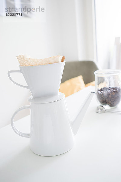 Weißer Kaffeefilter auf Kaffeekanne auf dem Tisch
