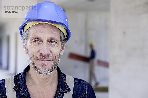 Lächelnder Arbeiter auf der Baustelle