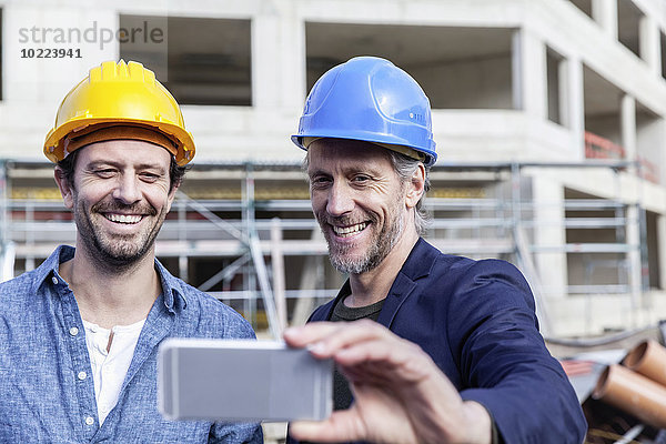 Zwei glückliche Männer auf der Baustelle mit einem Selfie