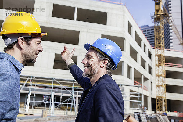 Zwei Männer auf der Baustelle mit Schutzhelmen