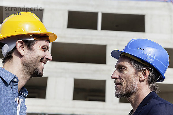 Zwei Männer auf der Baustelle mit Schutzhelmen