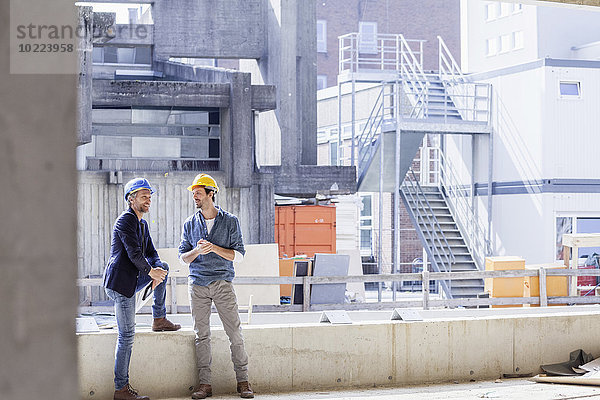 Zwei Männer auf der Baustelle mit Schutzhelmen