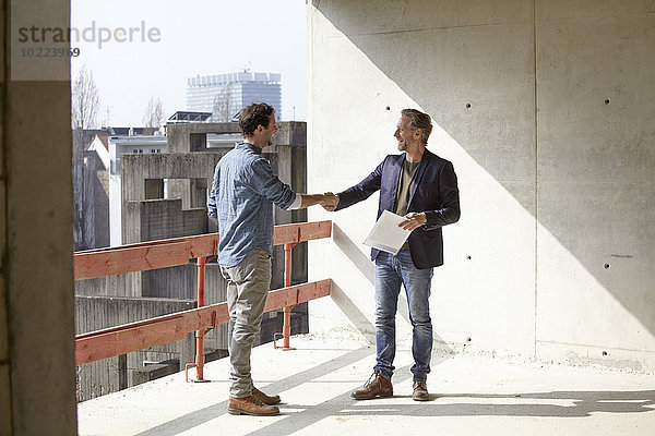 Zwei Männer auf der Baustelle beim Händeschütteln