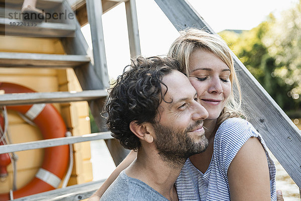 Ein glückliches Paar  das sich auf einem Hausboot umarmt.