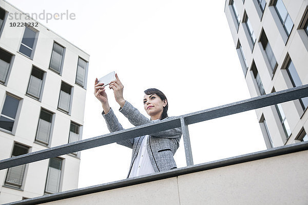 Geschäftsfrau nimmt Selfie mit Smartphone