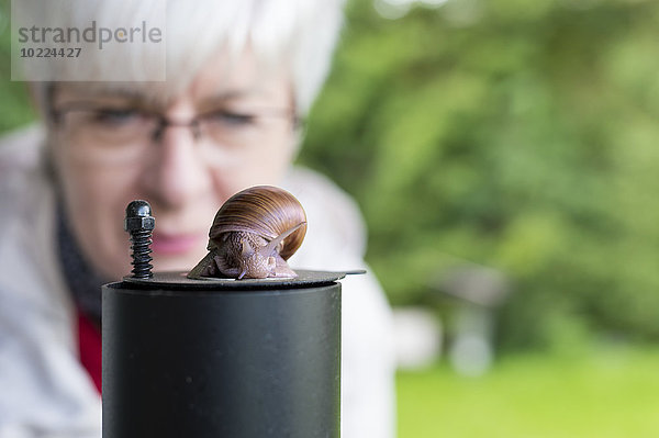 Seniorin beobachtet Schnecke