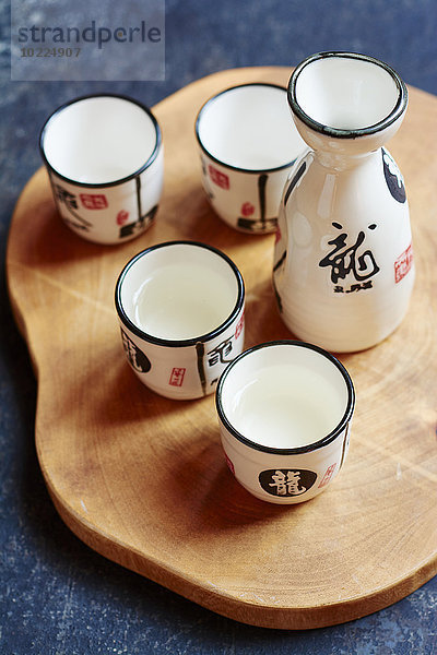 Sake-Set mit 4 Tassen und einer Karaffe  zwei Tassen mit Sake gefüllt