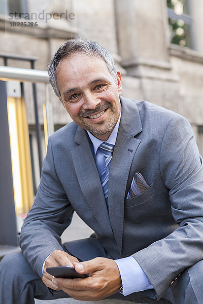 Porträt eines lächelnden Geschäftsmannes im grauen Anzug