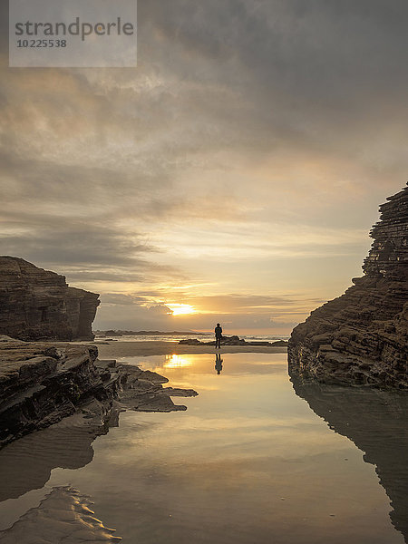 Spanien  Galizien  Ribadeo  Playa de Aguas Santas bei Sonnenuntergang  kleine Person am Strand