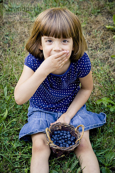 Kleines Mädchen isst Blaubeeren