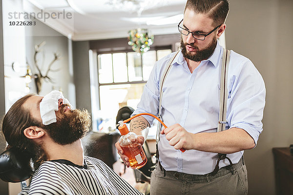 Friseur-Aftershave auf Bart eines Kunden