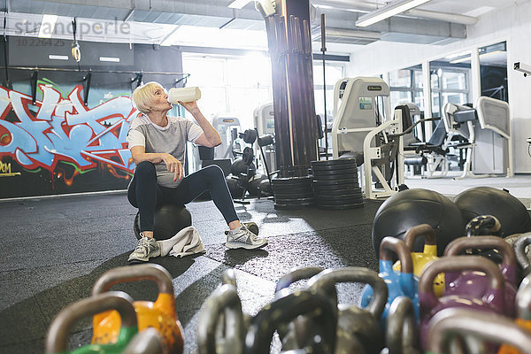 Seniorin im Fitnessstudio bei einer Pause