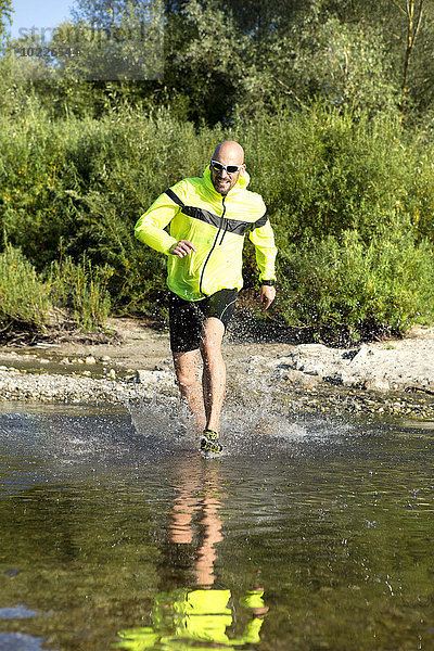 Mann in Sportbekleidung läuft im Wasser