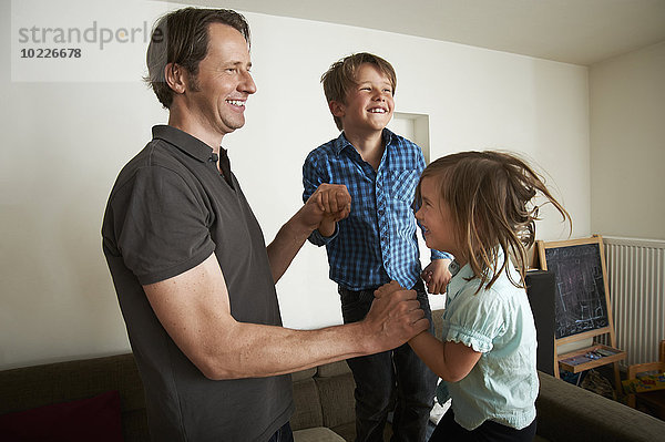 Vater spielt mit seinen Kindern zu Hause