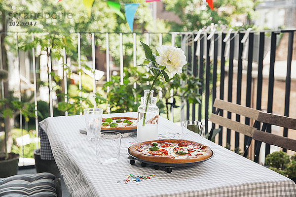 Hausgemachte Pizza auf einem gedeckten Tisch