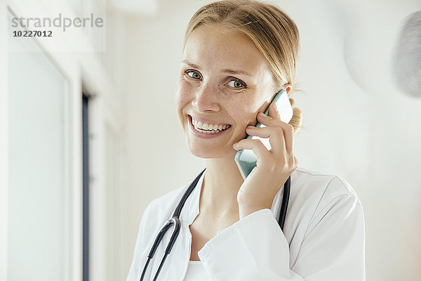 Lächelnde Ärztin im Gespräch mit dem Handy