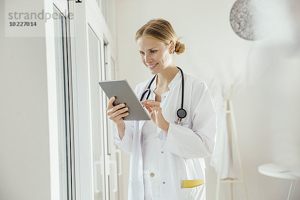 Lächelnde Ärztin mit digitalem Tablett