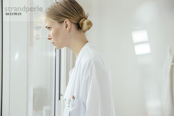Seriöse Ärztin mit Blick aus dem Fenster