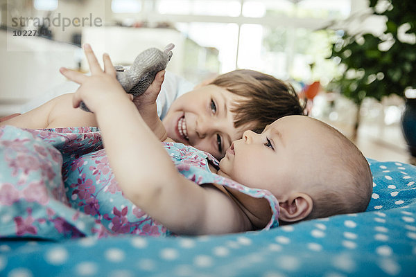 Baby Mädchen und Bruder kuscheln zu Hause