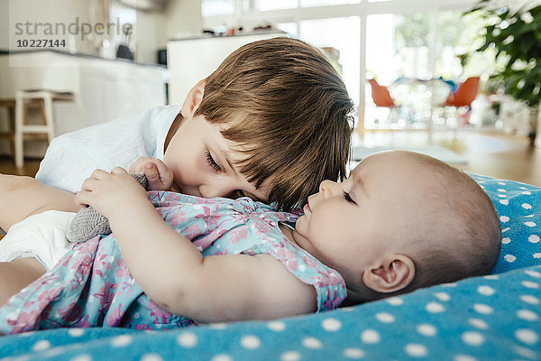 Baby Mädchen und Bruder kuscheln zu Hause