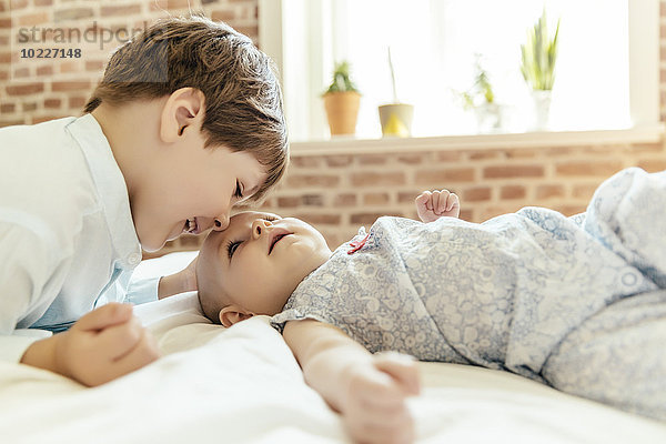 Baby Mädchen und Bruder kuscheln zu Hause