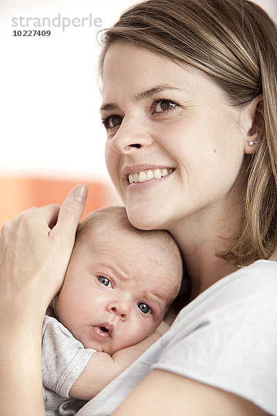 Porträt einer glücklichen jungen Frau mit ihrem Baby