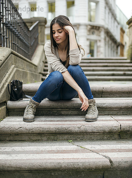 Spanien  Oviedo  junge Frau auf einer Treppe in der Altstadt sitzend