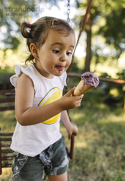 Kleines Mädchen  das versucht  Eis zu essen.